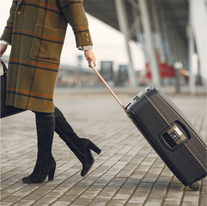 Business woman carrying a travel suitcase