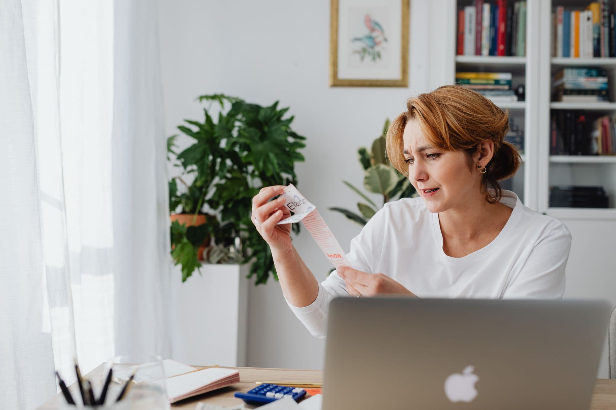 Woman looking at a paper receipt.